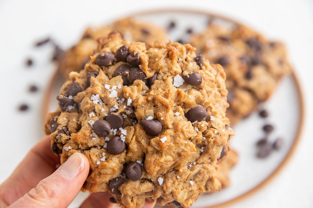 Horizontal photo of hand holding a giant peanut butter oatmeal cookie