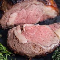 Garlic Herb Prime Rib on a cutting board, sliced into a steak.