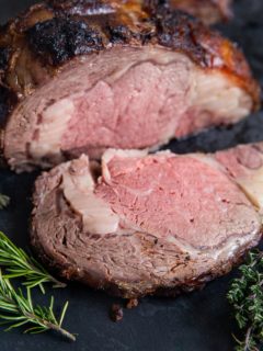 Garlic Herb Prime Rib on a cutting board, sliced into a steak.