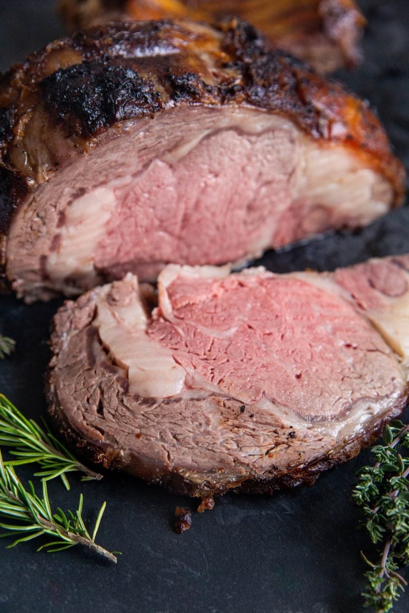 Garlic Herb Prime Rib on a cutting board, sliced into a steak.