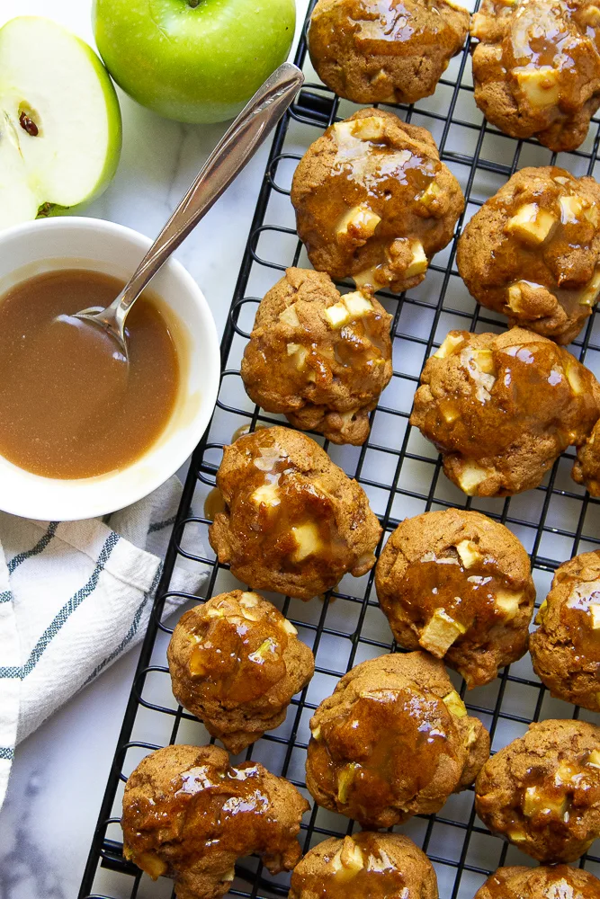 Apple Cookies with Maple Glaze on a cooling wrack with caramel sauce to the side.