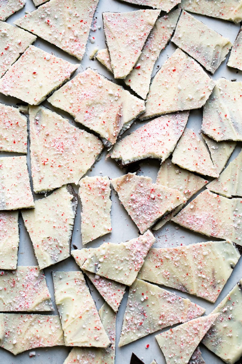 Homemade chocolate peppermint bark broken up on a white backdrop.