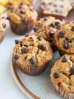 Close up angled shot of a plate of chocolate chip banana muffins