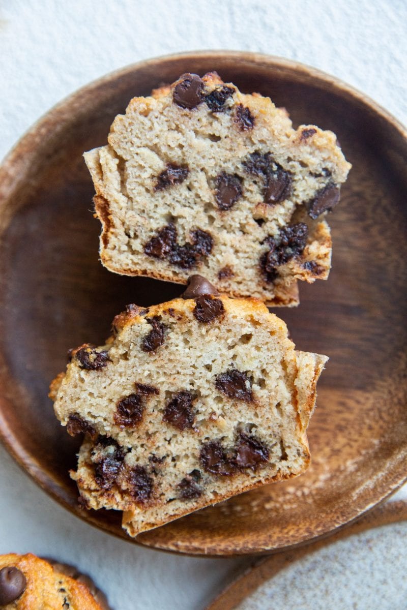 wooden plate with a banana muffin sliced in half so you can see the inside.