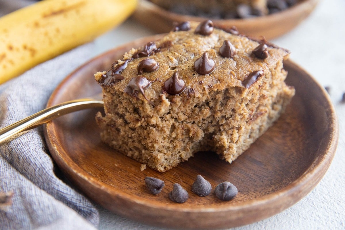 Horizontal photo of a slice of banana baked oatmeal on a wooden plate.