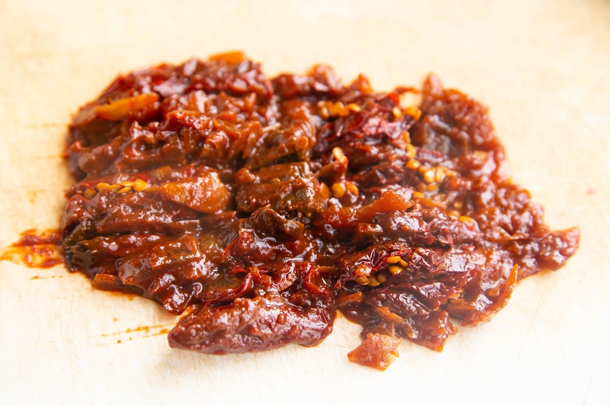 Chopped chipotle peppers on a cutting board.