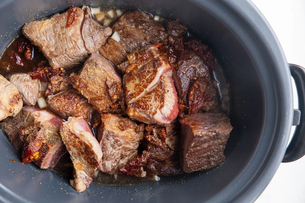 All of the ingredients for the barbacoa beef in a crock pot, ready to slow cook.