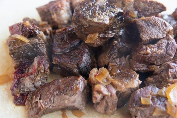 Chunks of cooked meat on a cutting board, ready to be shredded.