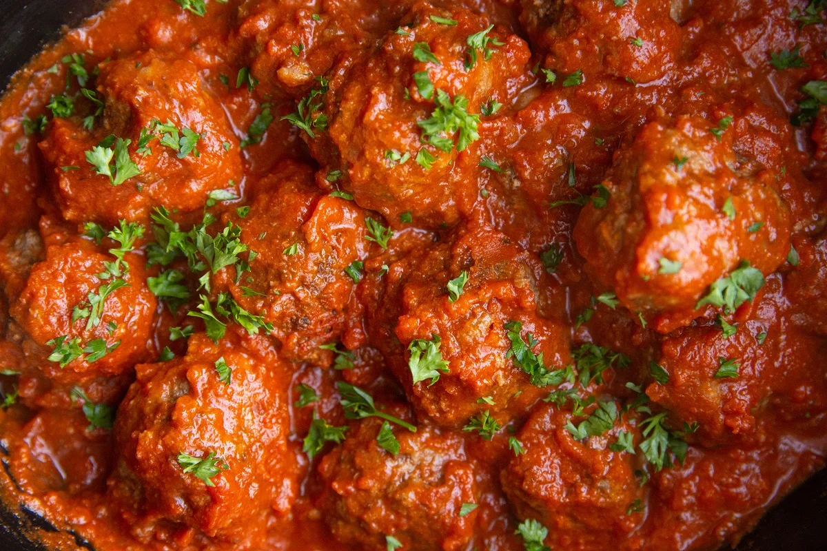 Horizontal image of finished meatballs in a crock pot.