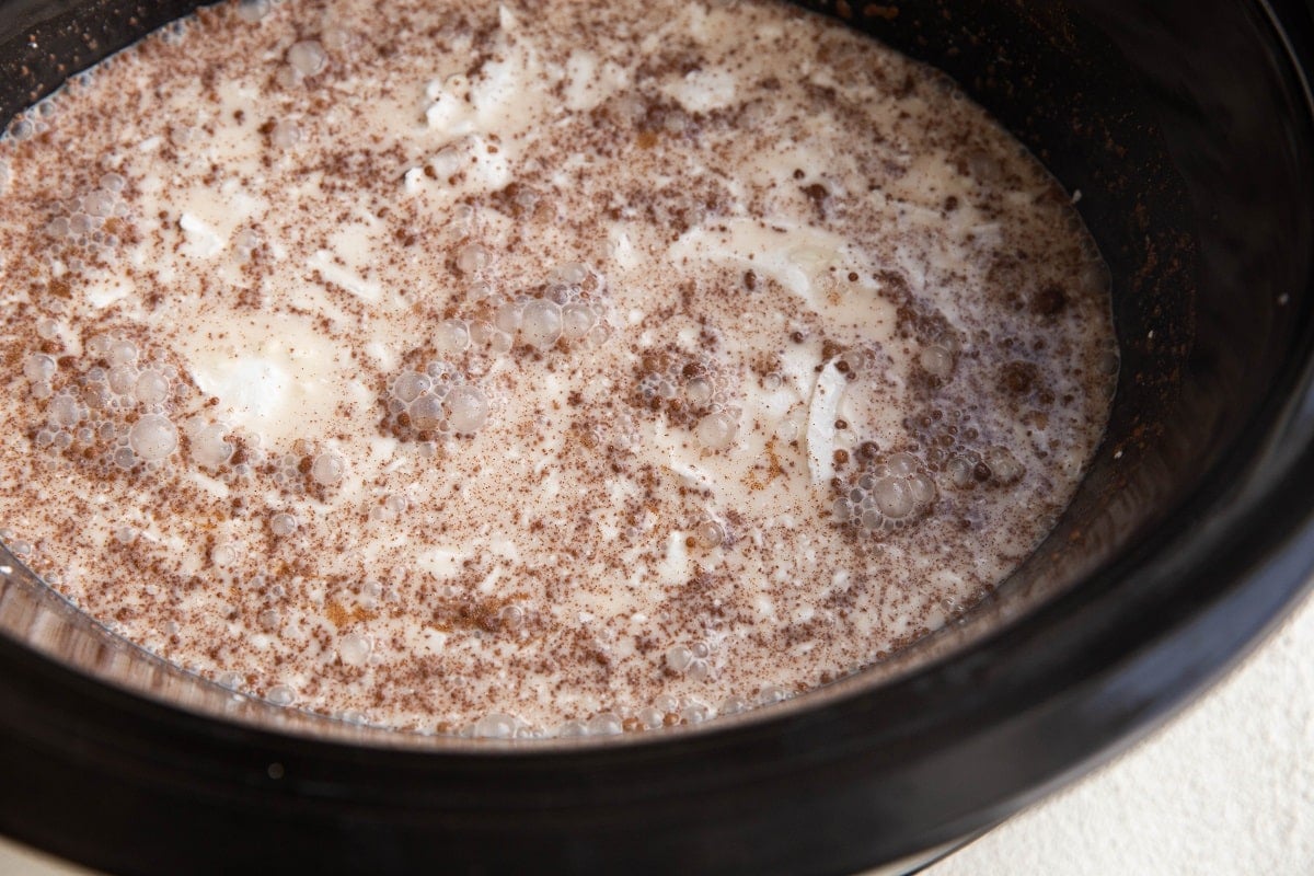 Ingredients for rice pudding stirred up in a slow cooker