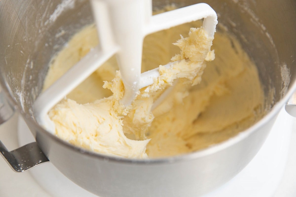 Butter and sugar mixed together in a stand mixer in a creamy substance.