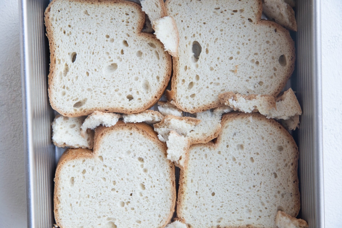 Sliced bread at the bottom of a baking dish.