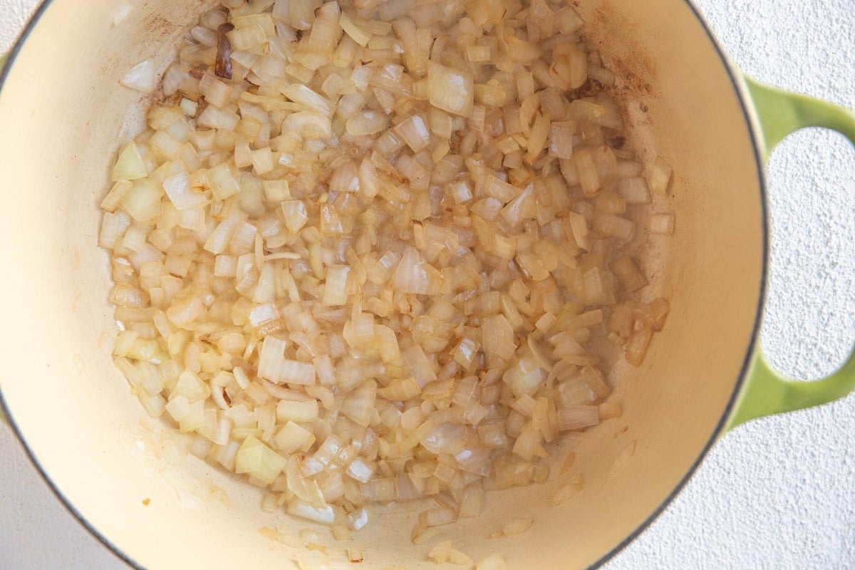 Onions sautéing in a large pot in the bacon fat.