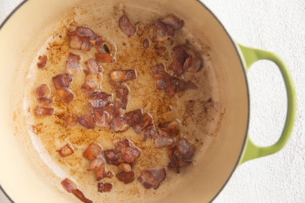 Chopped bacon cooking in a large stock pot