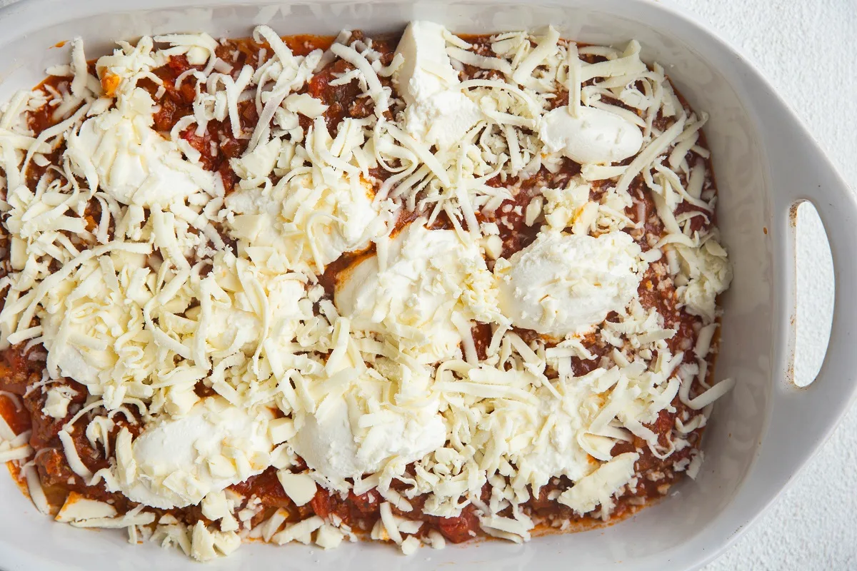 Mozzarella cheese sprinkled over the ricotta, sauce, and noodles to create the first layer of lasagna.