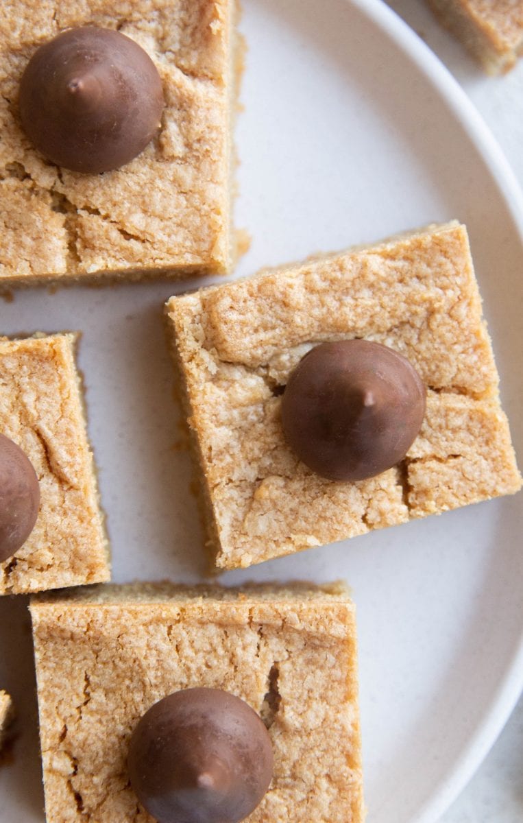 Close up top down image of peanut butter blossoms on a white plate.