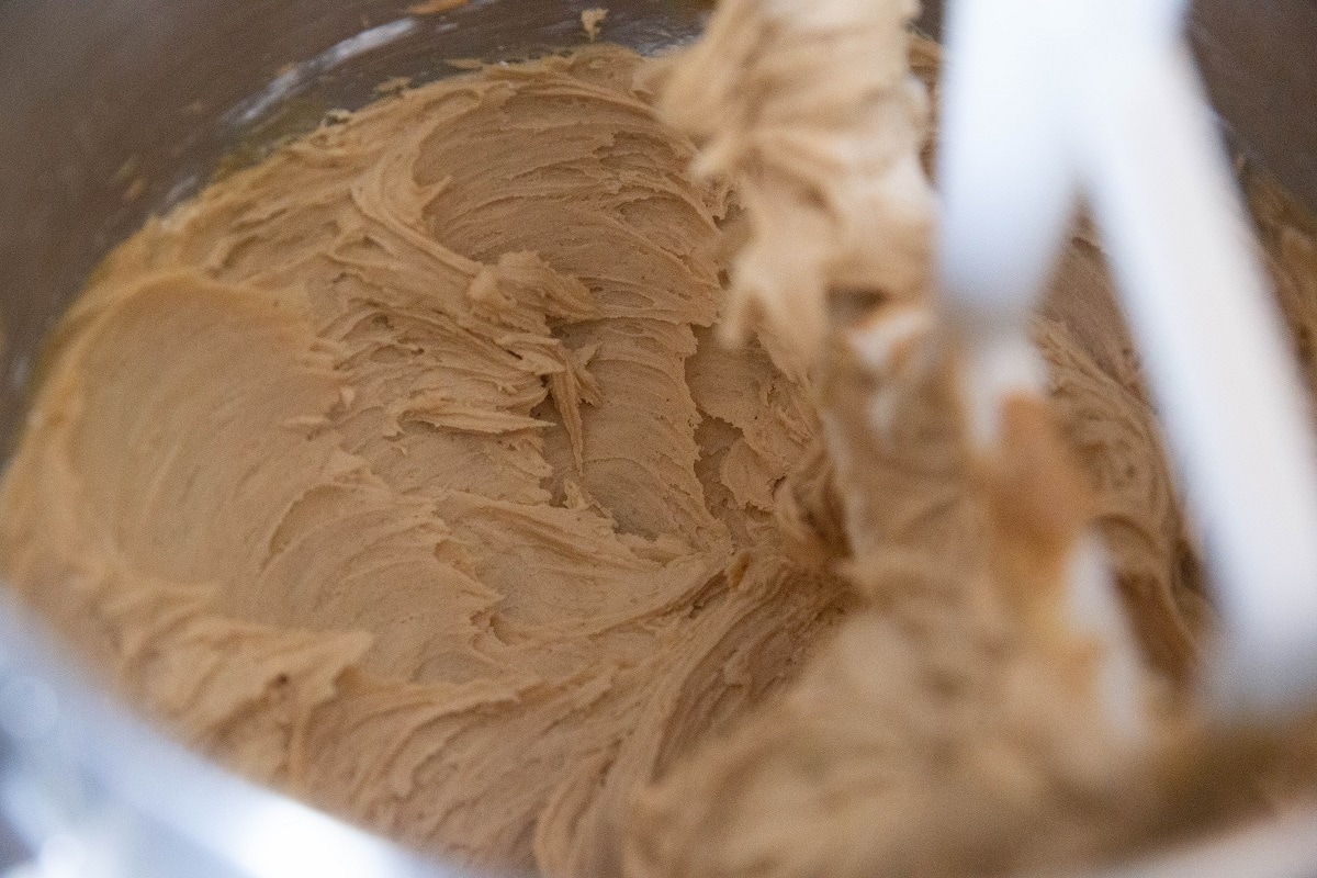 Peanut butter, sugar, and unsalted butter mixing in a stand mixer.
