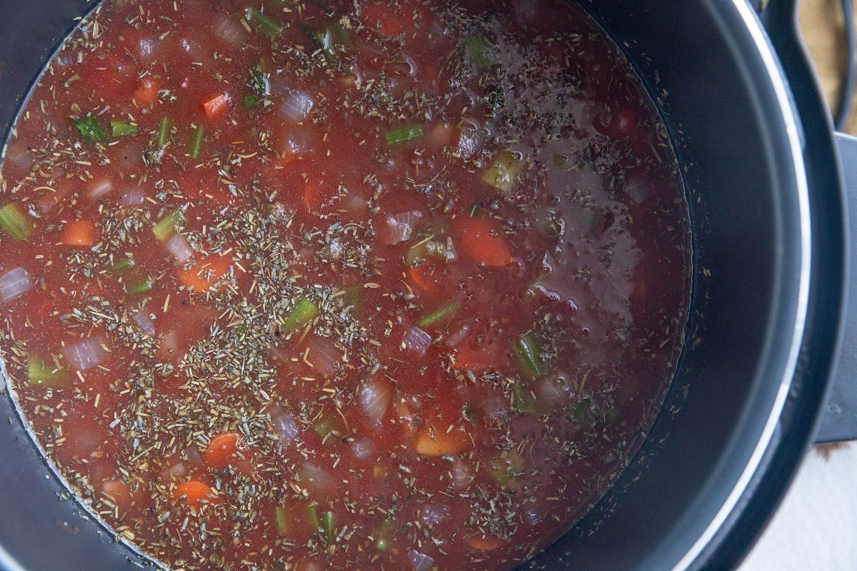 All of the ingredients for lentil soup stirred up in an Instant Pot, ready to cook.