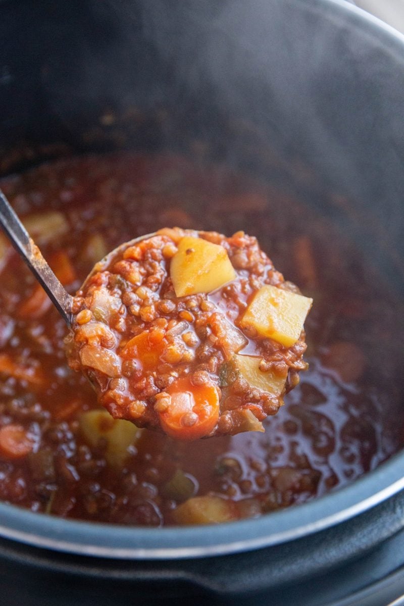 Ladle scooping lentil soup out of the Instant Pot