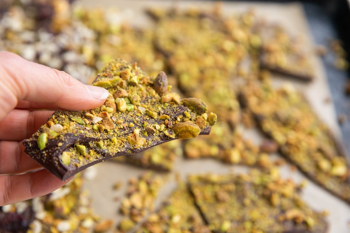 hand holding a chunk of pistachio bark.