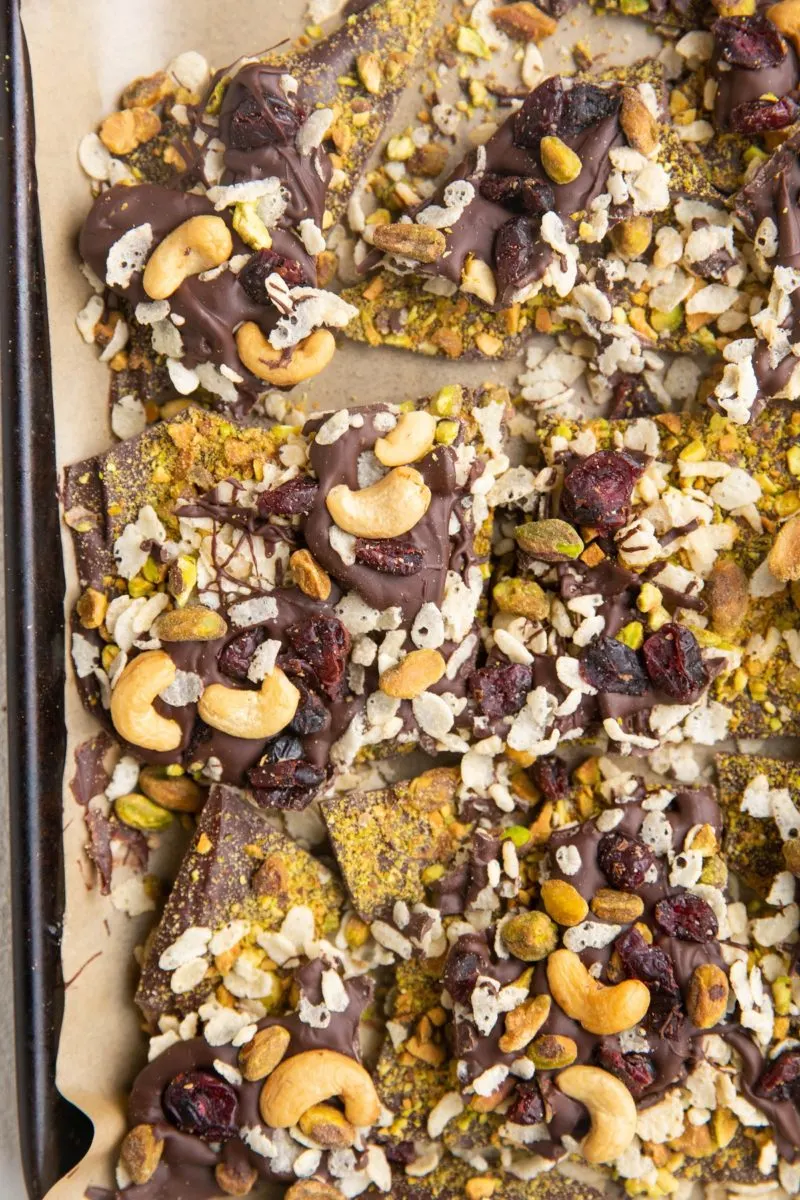 Top down photo of chocolate bark with pistachios, cashews, dried cranberries, crispy rice cereal.