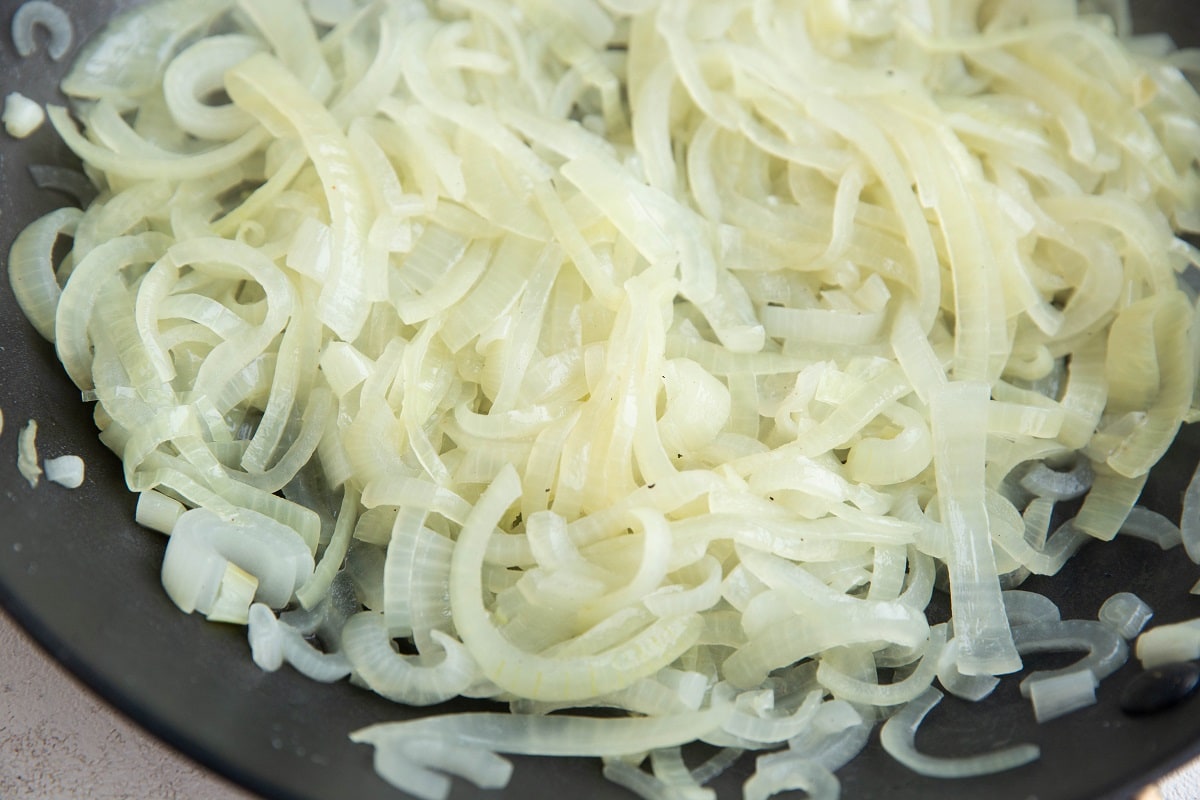 Onions sautéing in a skillet.