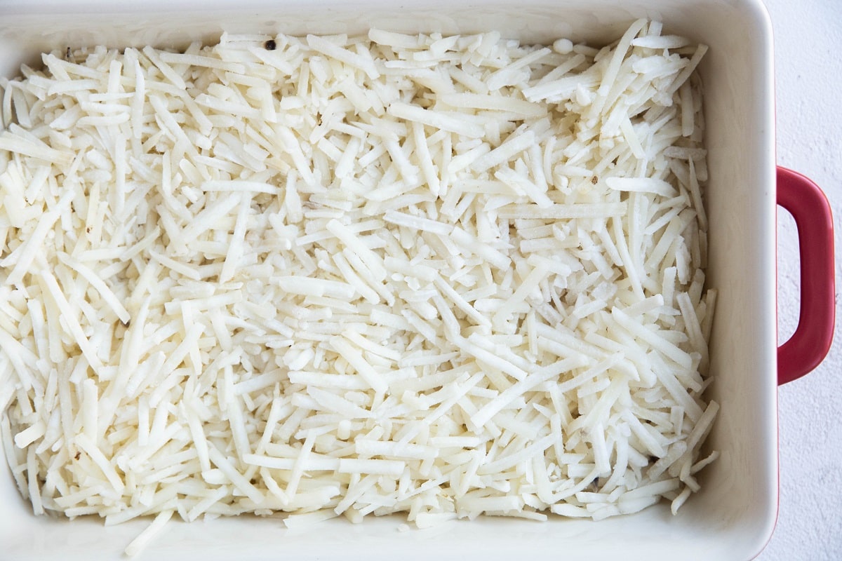 Hash browns at the bottom of a casserole dish.