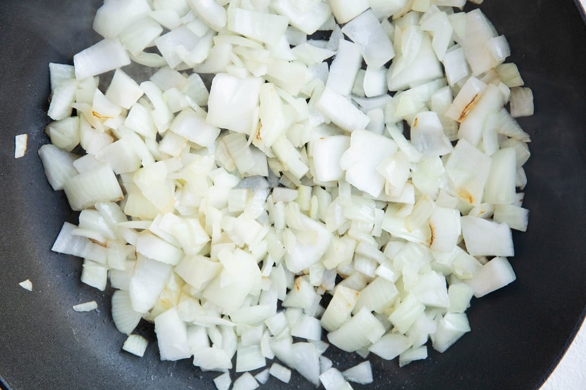 Chopped onions cooking in a skillet.