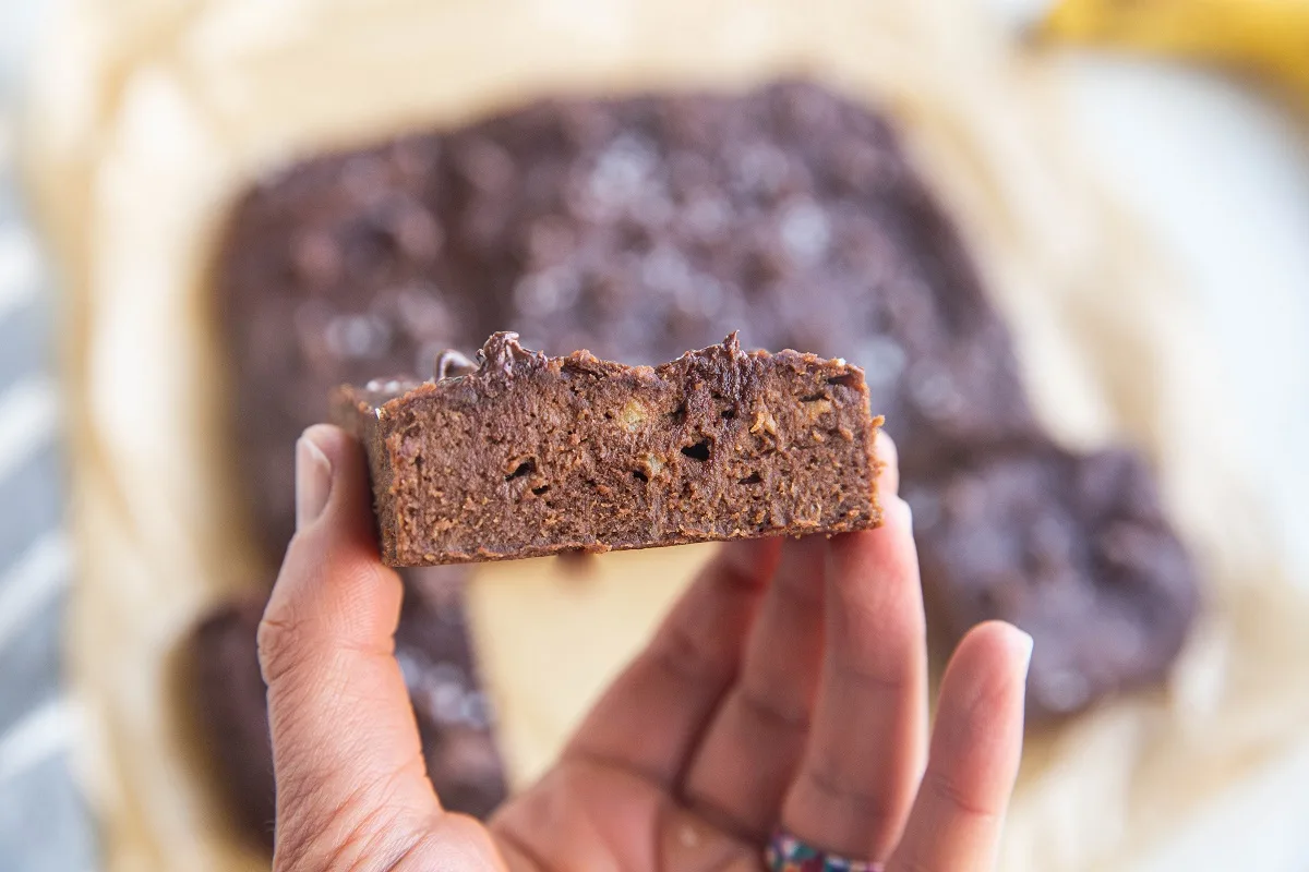 Hand holding a banana brownie so you can see the inside.