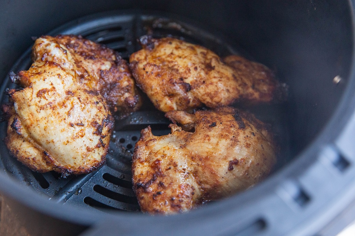 Cooked chicken thighs in an air fryer.