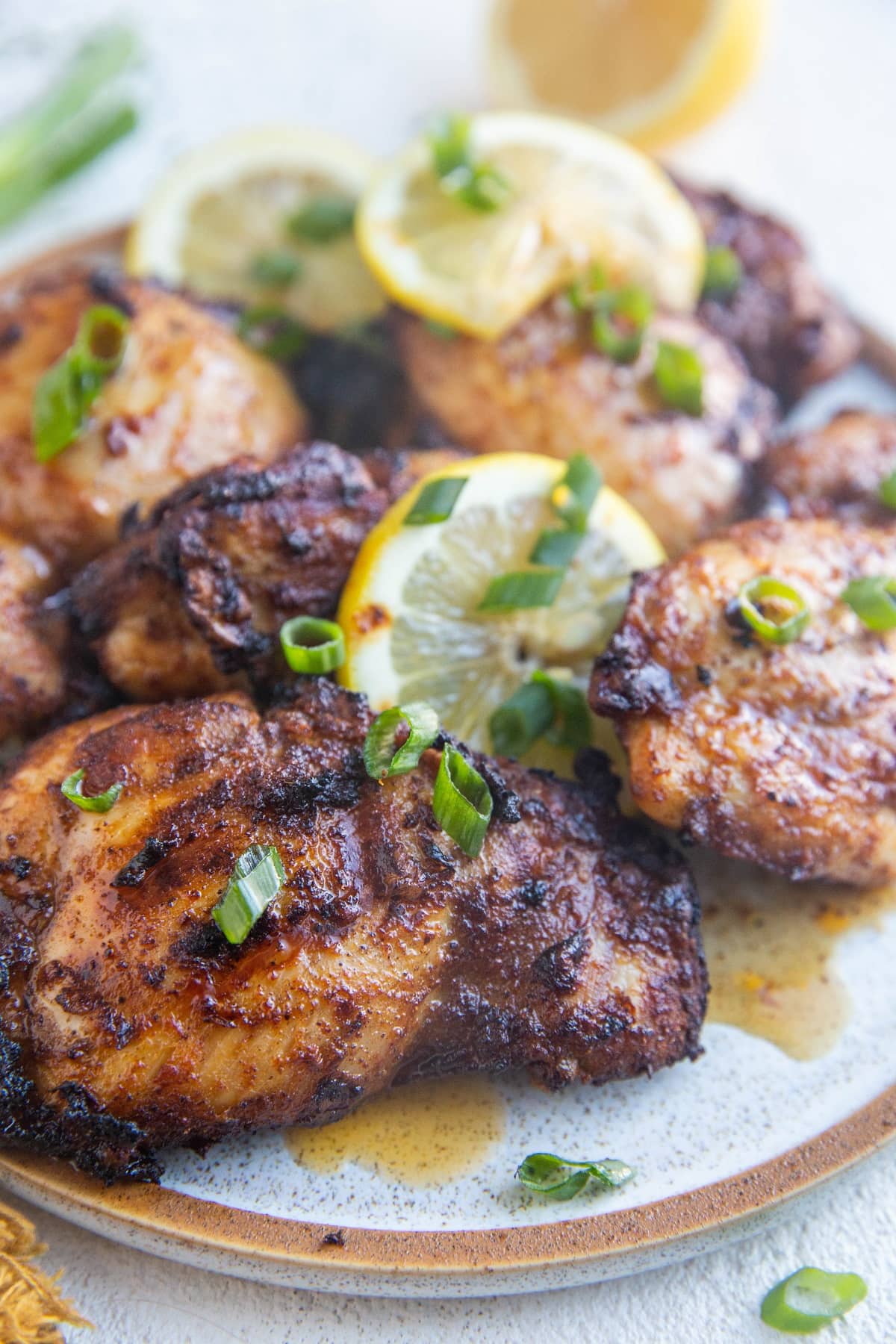 Plate of Mediterranean chicken thighs on a white background, ready to serve.