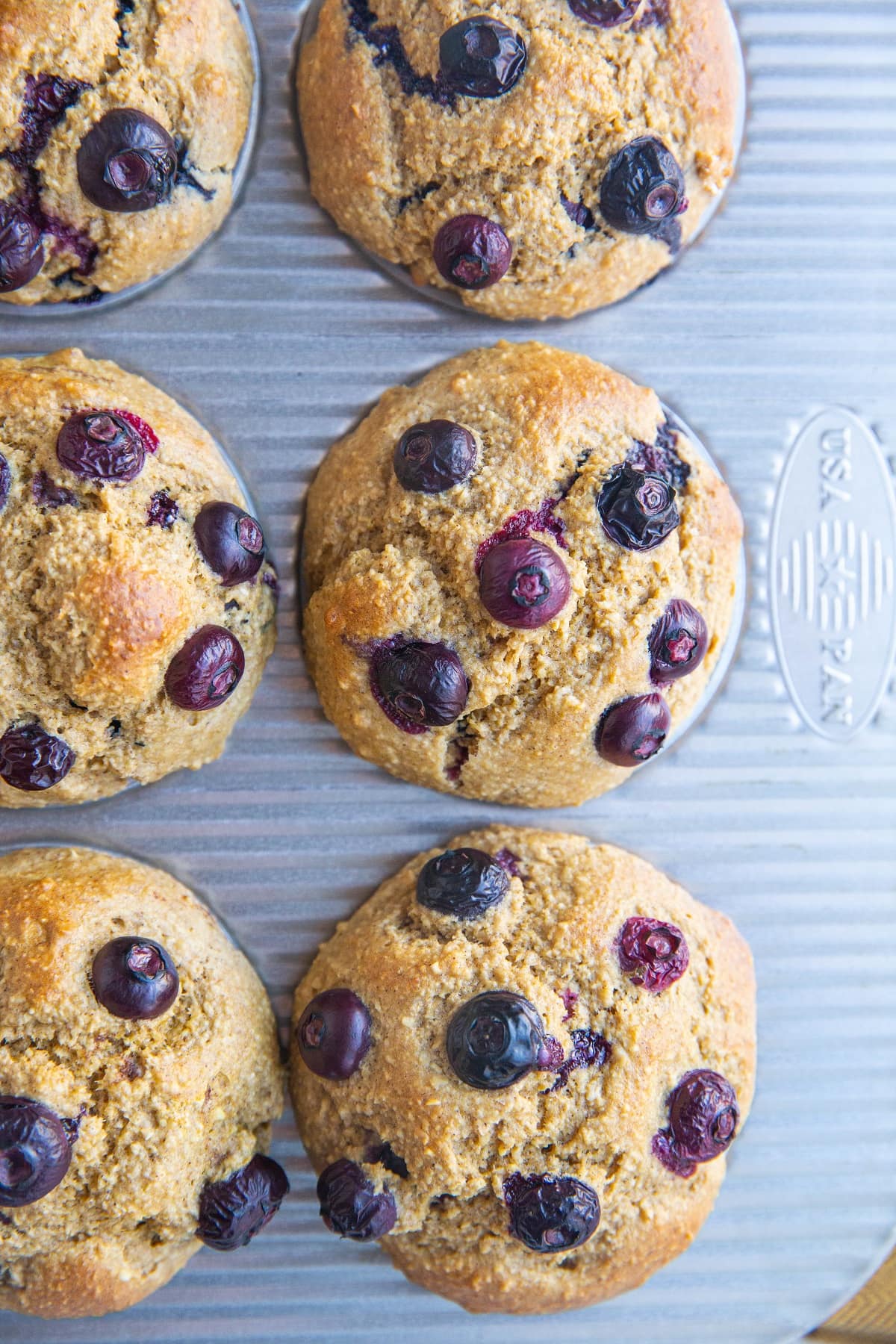 Muffin tray with blueberry banana muffins inside, fresh out of the oven.