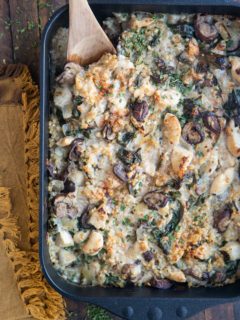 Large cast iron casserole dish full of chicken, rice, mushrooms, and creamy sauce.