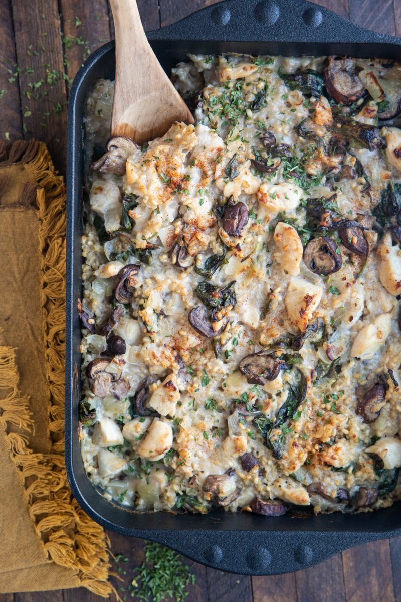 Large cast iron casserole dish full of chicken, rice, mushrooms, and creamy sauce.