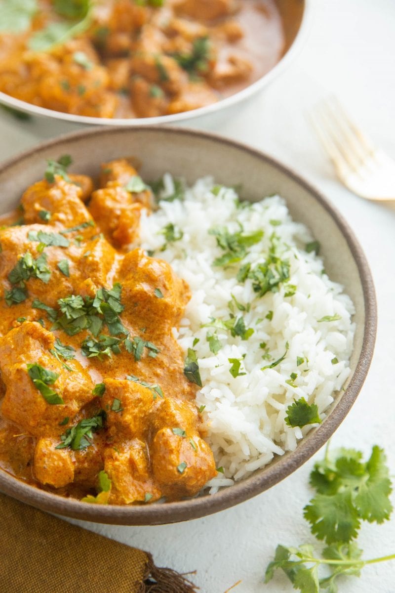 Angled shot of a bowl of chicken tikka masala with white rice.