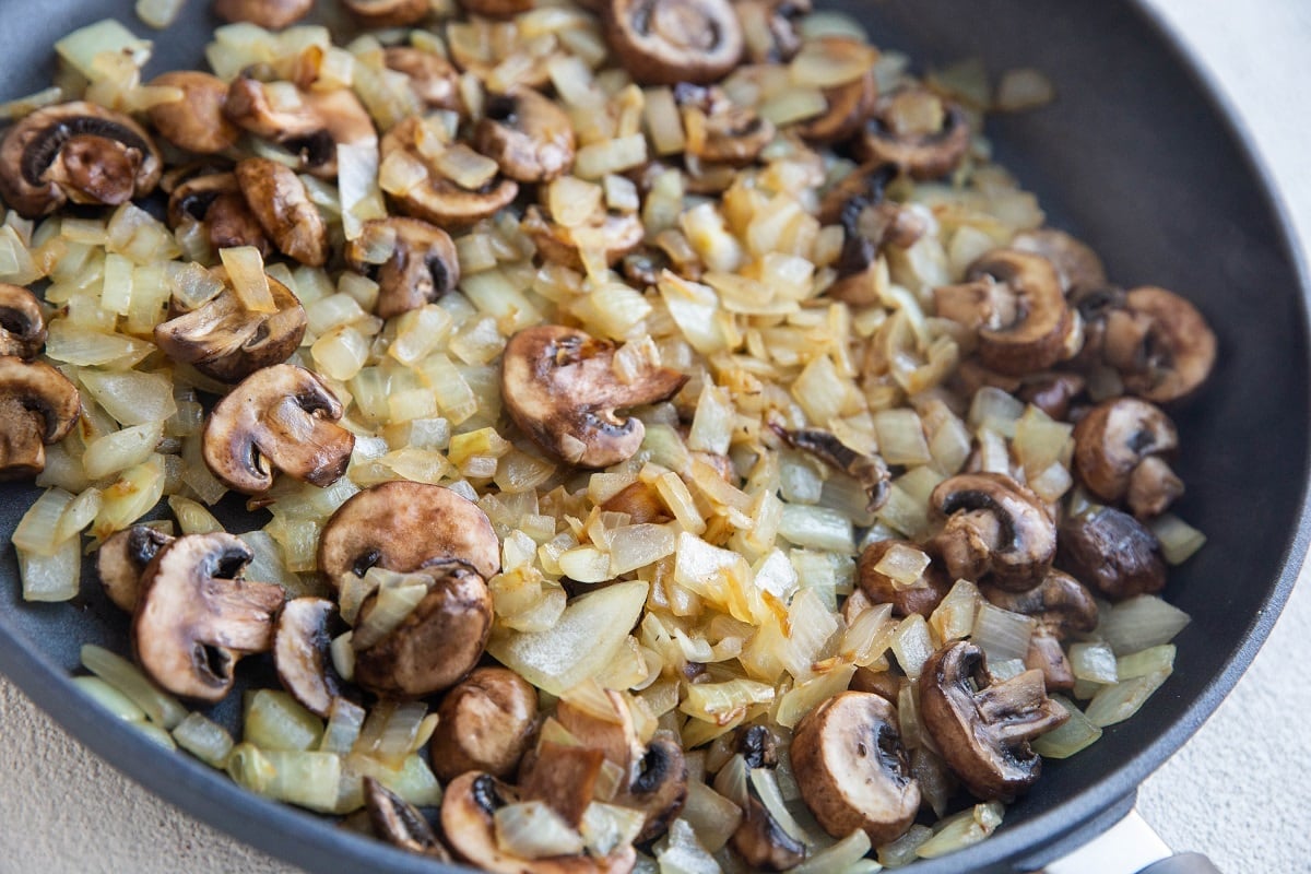Onions and mushrooms cooking in a skillet