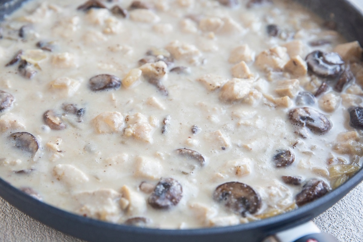 Chicken stroganoff sauce cooking in a skillet.