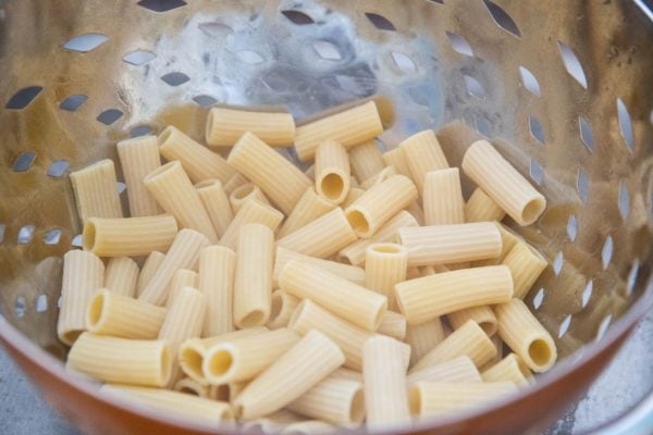 Cooked noodles in a collander.