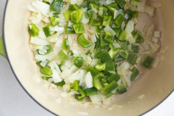 Onion and bell pepper cooking in a large soup pot