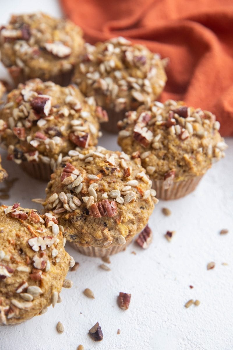 Angled shot of healthy morning glory muffins on a white background with a red napkin, ready to eat.