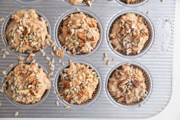 Morning glory muffin batter in a muffin tray.