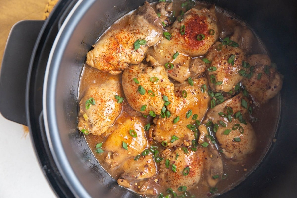 Horizontal image of an Instant Pot full of cooked chicken thighs