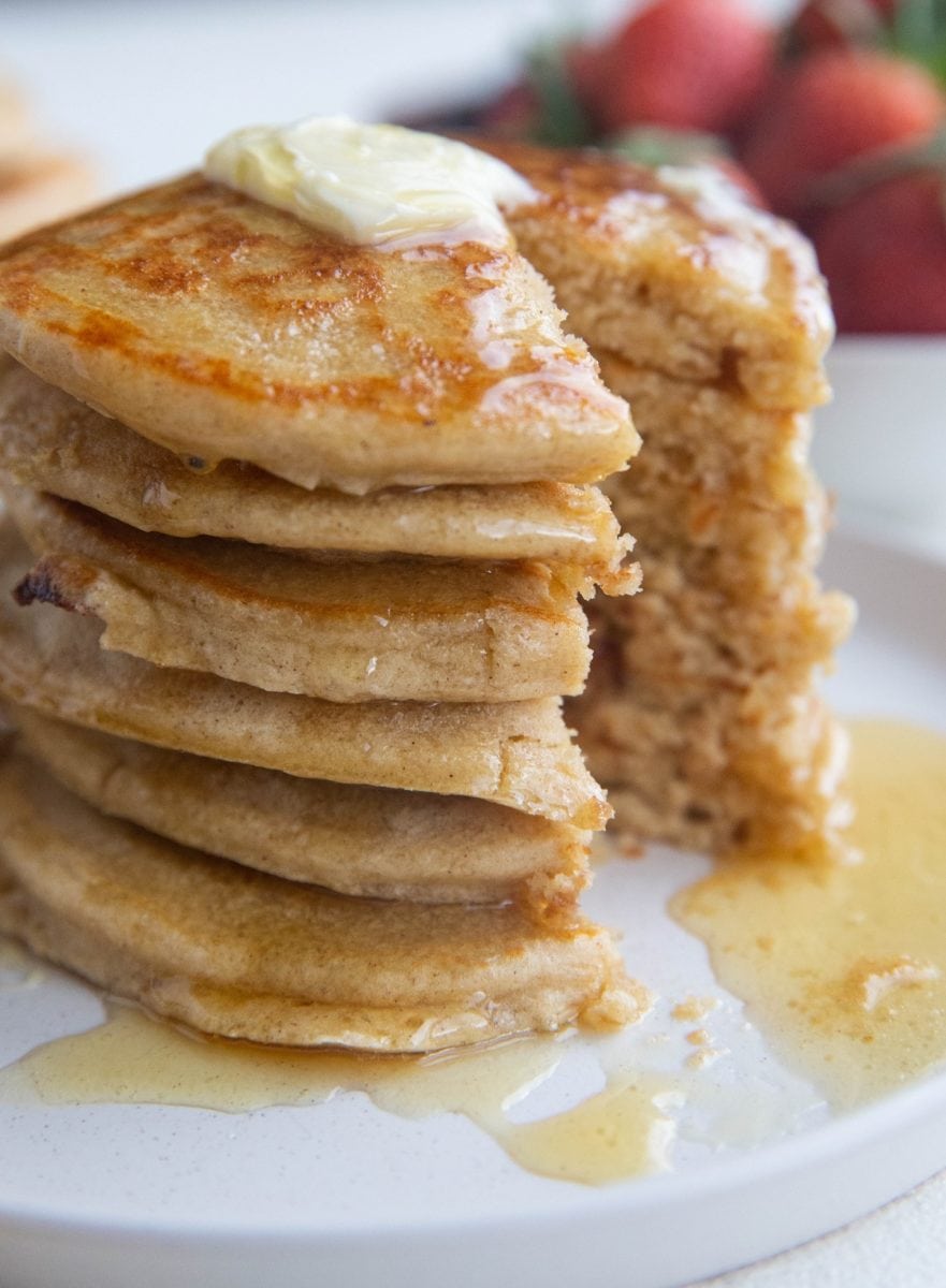 Close up stack of pancakes with a bite taken out.