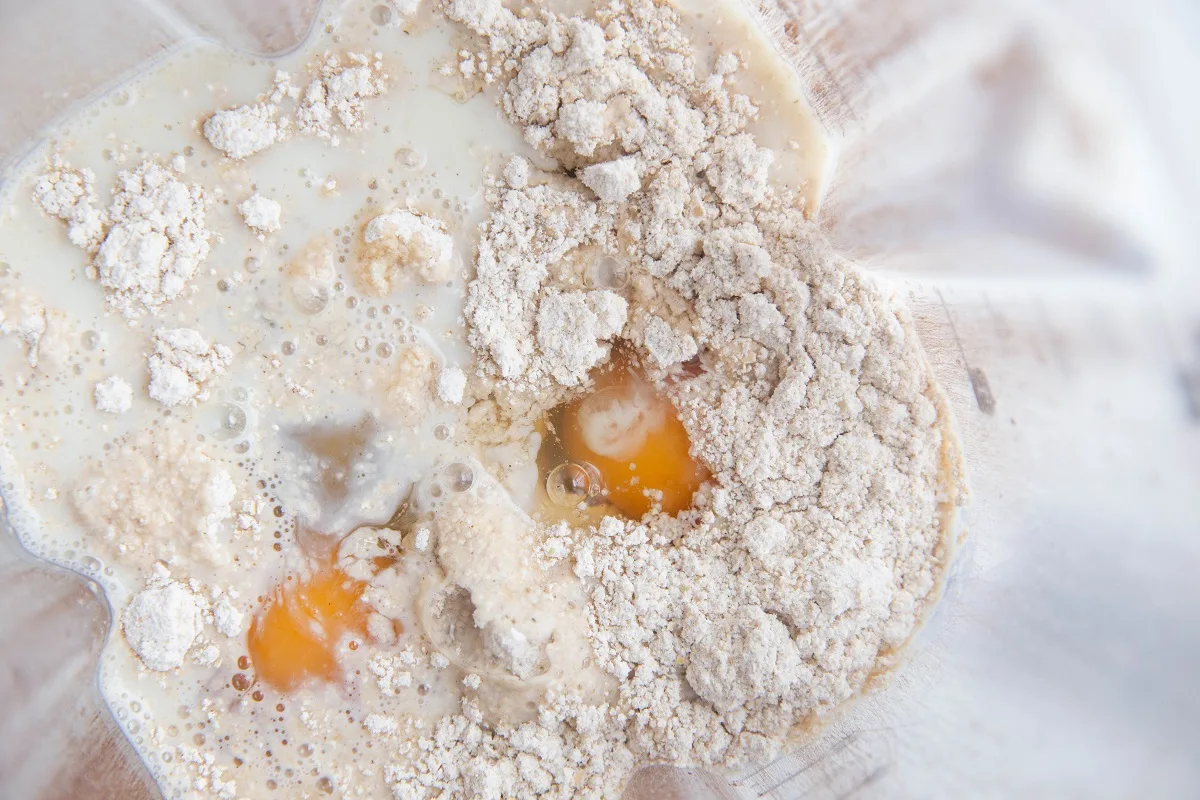 Wet ingredients and dry ingredients for oatmeal pancakes in a blender.