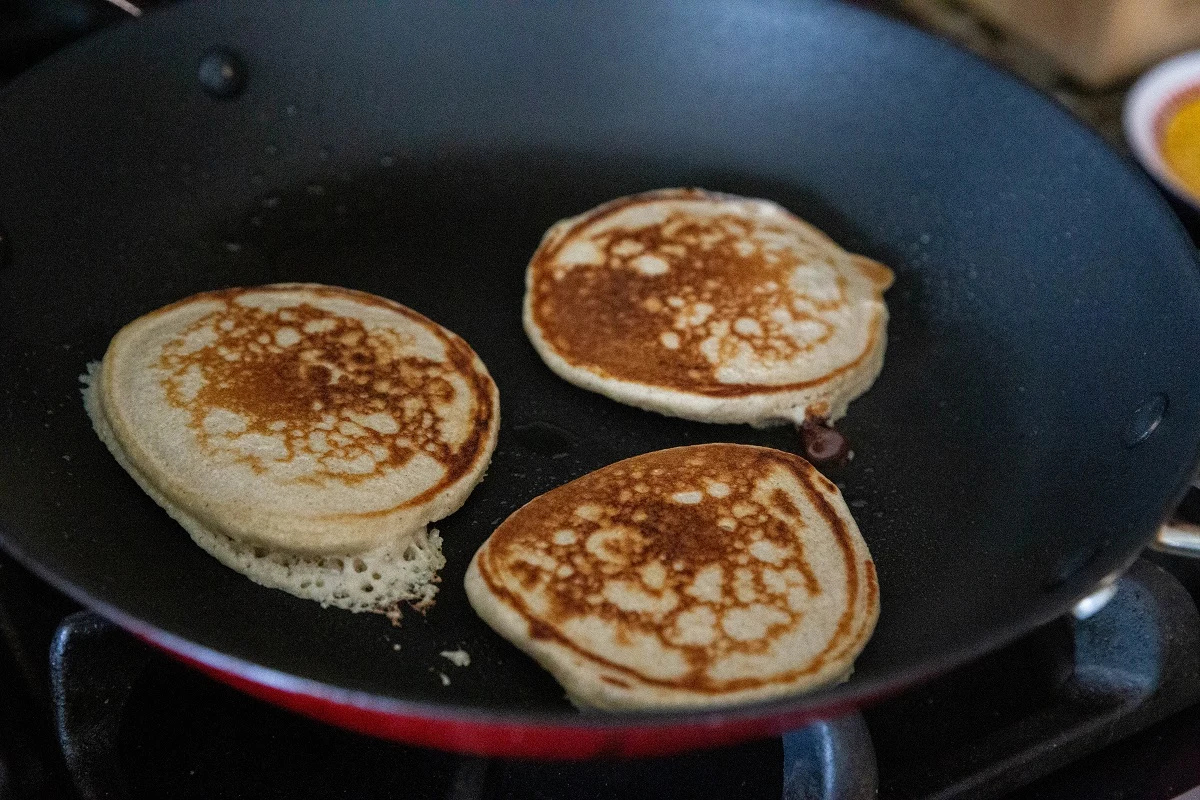 Pancakes that had just been flipping in a nonstick skillet with golden-brown tops.