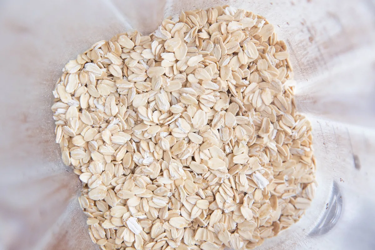 Rolled oats in a blender, ready to be blended into a flour.