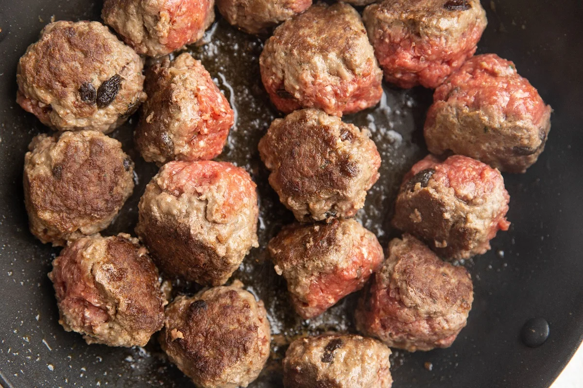 Meatballs browning in a skillet