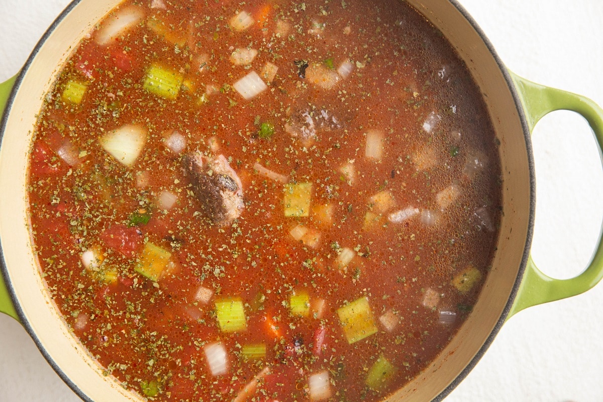 all of the ingredients for the meatball soup in a Dutch oven, ready to cook