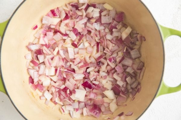Red onions sautéing in a pot