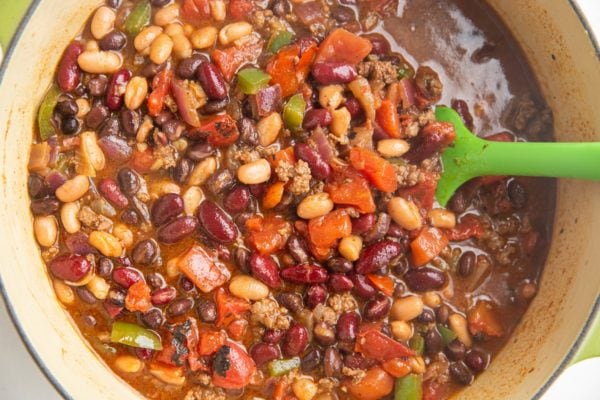 Horizontal image of a big pot of turkey chili, ready to bring to a boil and cook.